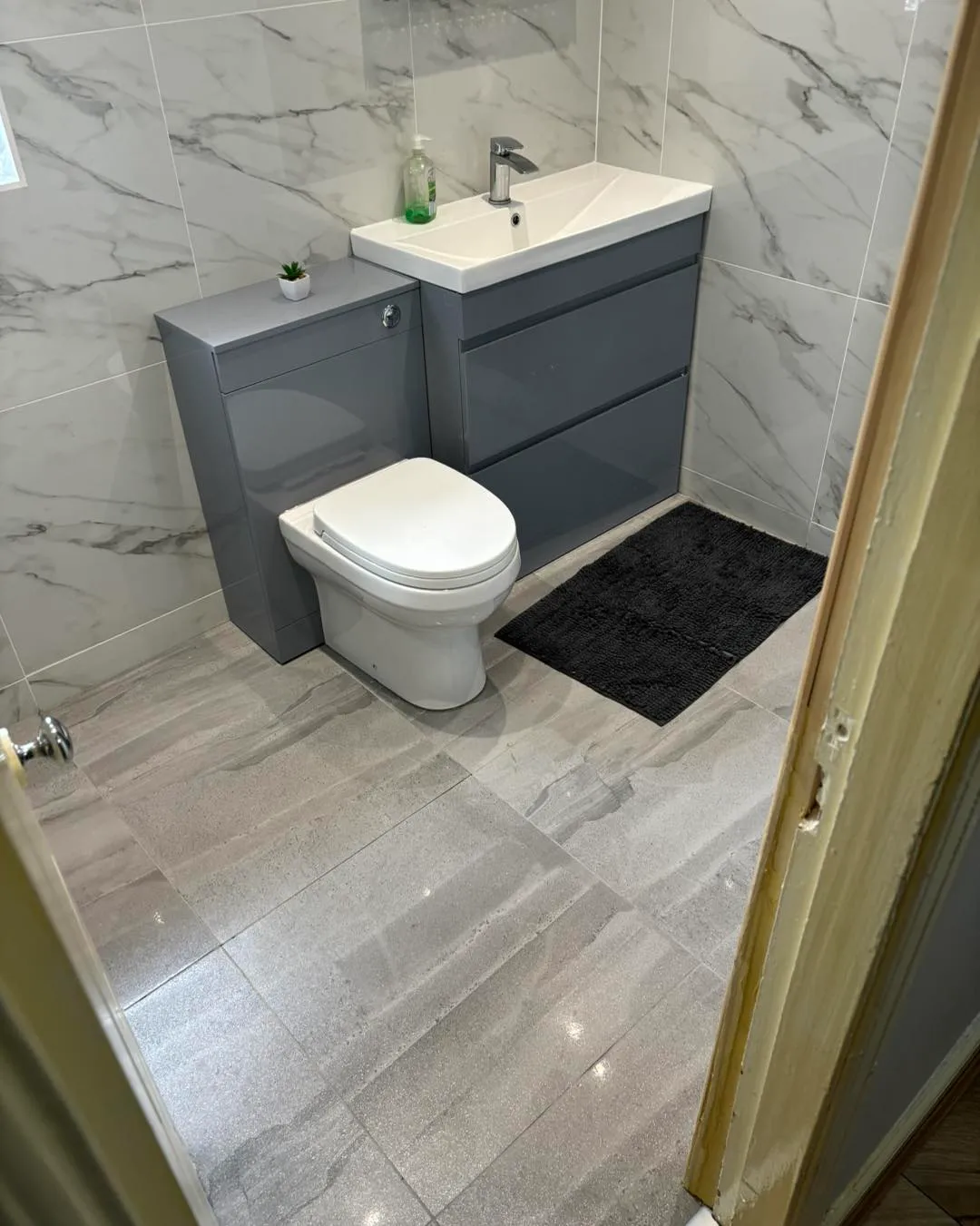 toilet next to a sink in the corner